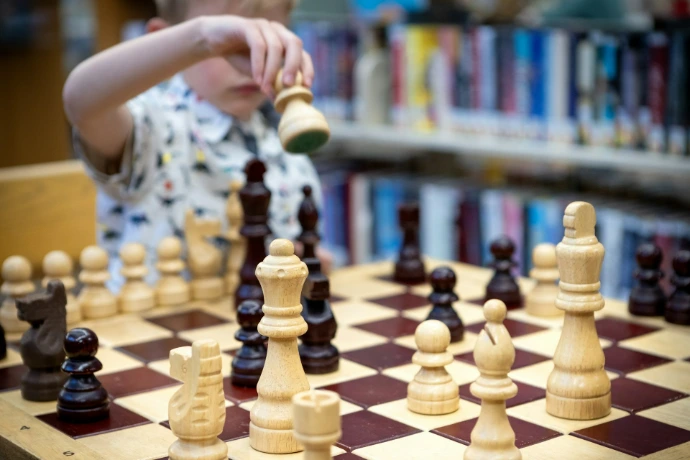 A young boy plays a game of chess.